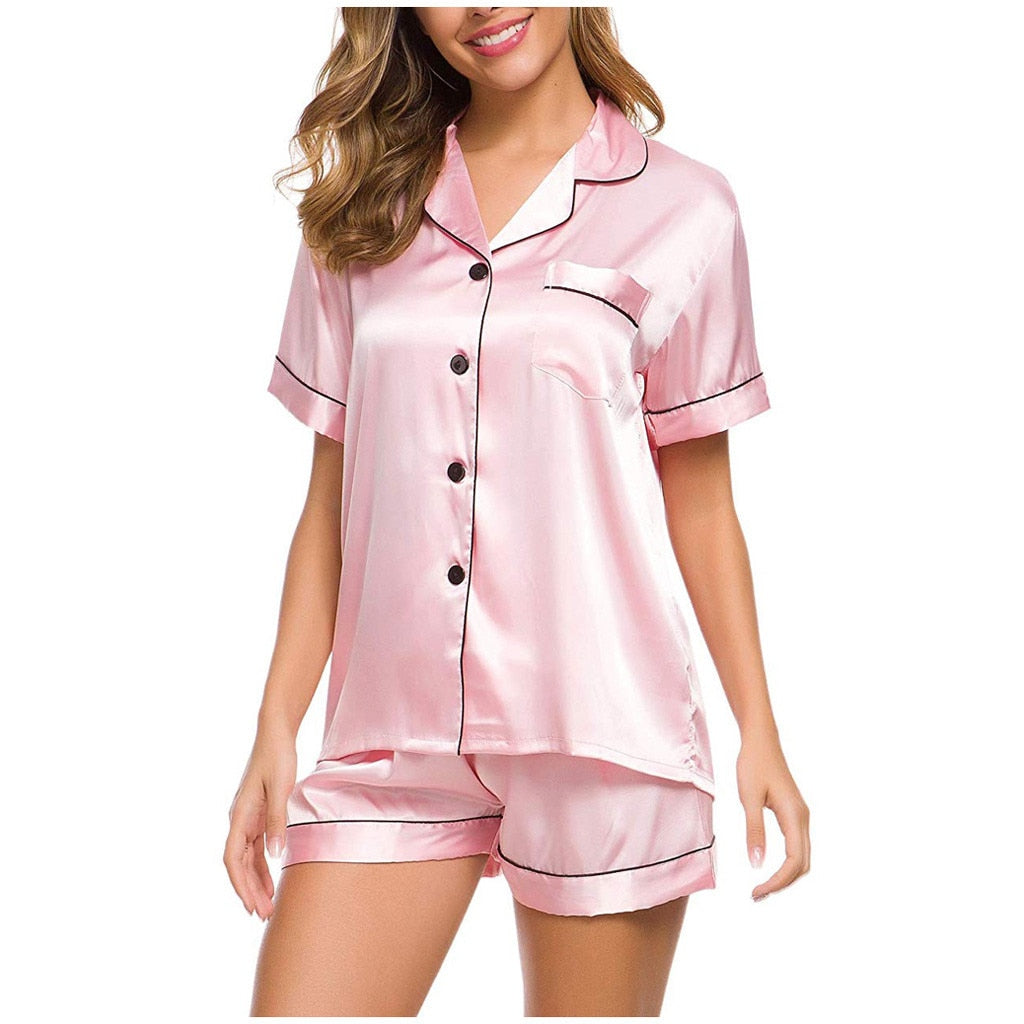 Woman wearing light pink satin pajama set with black piping, FashionRay loungewear style