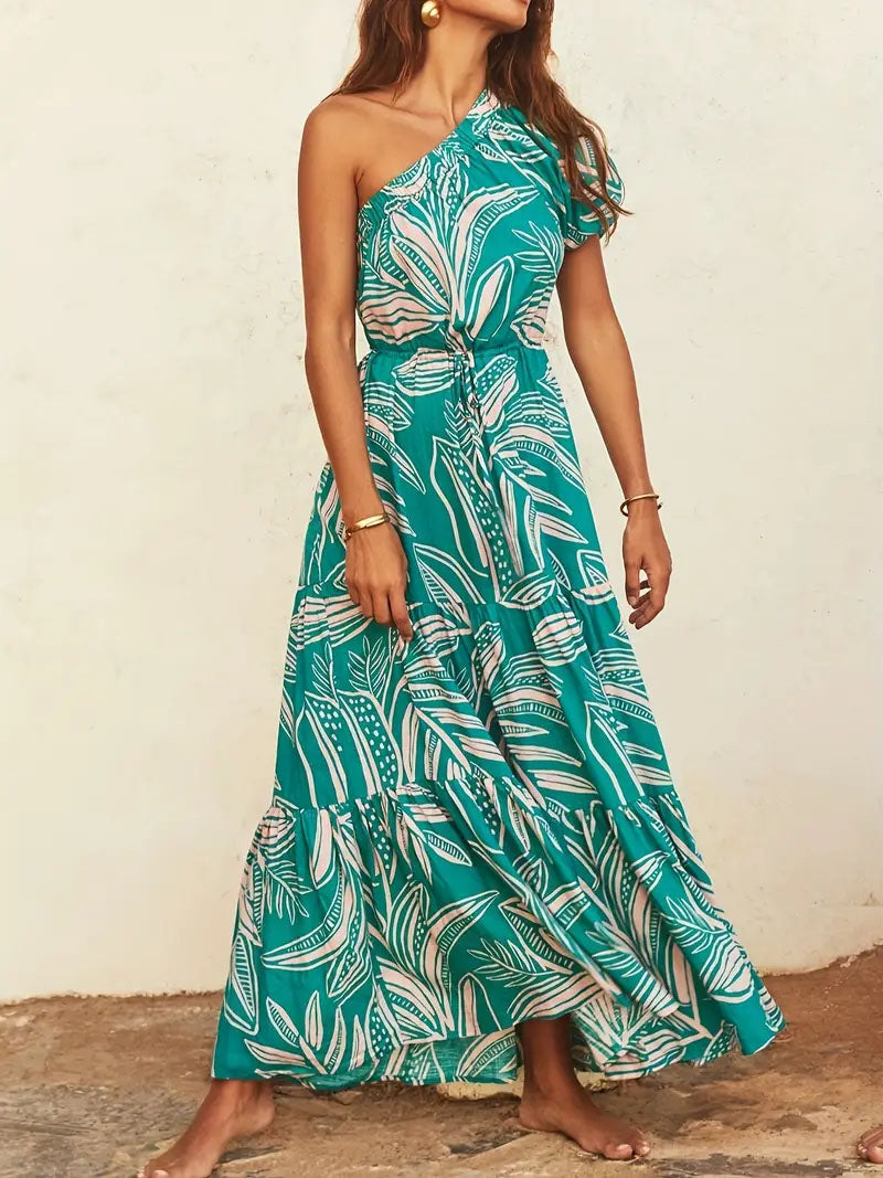 Woman in teal one-shoulder maxi dress with tropical leaf print, FashionRay style