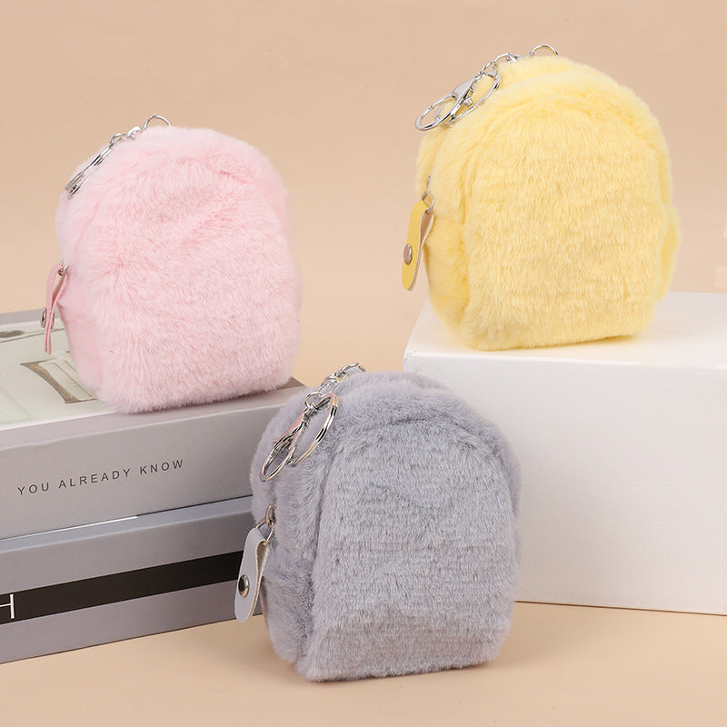 Pastel pink, yellow, and gray plush mini backpack keychains on display, FashionRay accessories