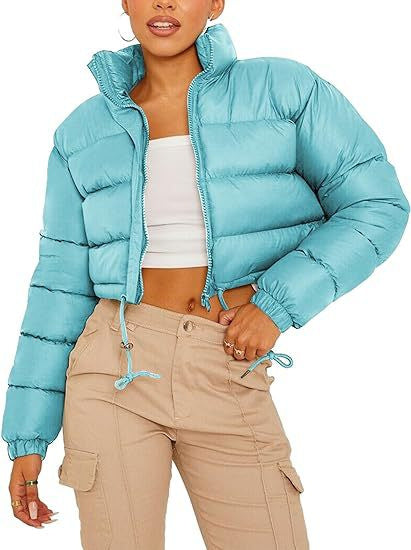 Woman models trendy light blue puffer jacket, white crop top, beige cargo pants for FashionRay