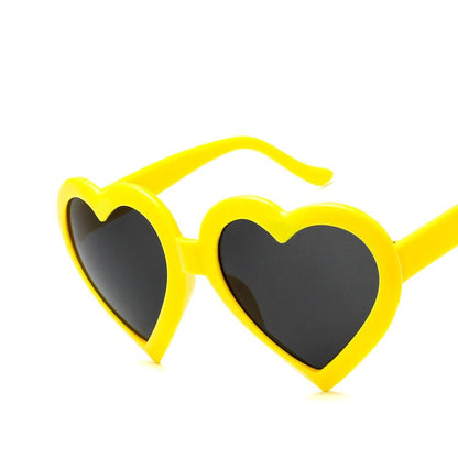 Yellow heart-shaped sunglasses with black lenses on white background, FashionRay accessory