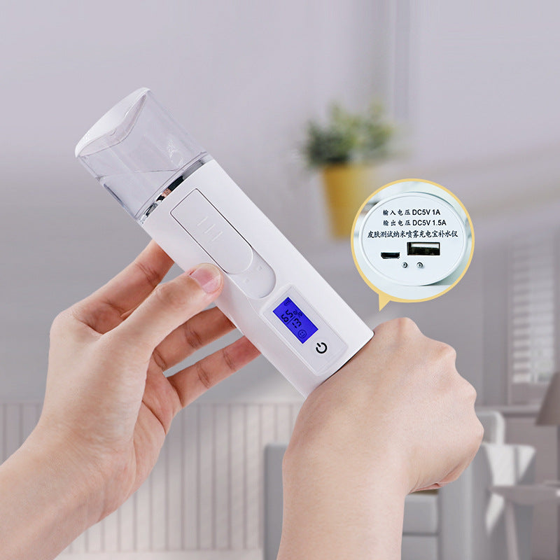 Hand holding a white portable facial mist sprayer with digital screen, modern home background