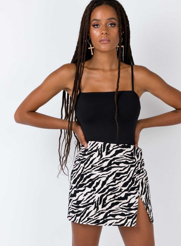 Woman in a black tank top and zebra print mini skirt with side slit, FashionRay trendy style
