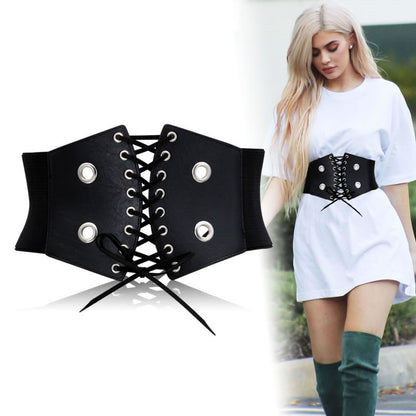 Trendy black lace-up corset belt styled over white dress, FashionRay bold accessory