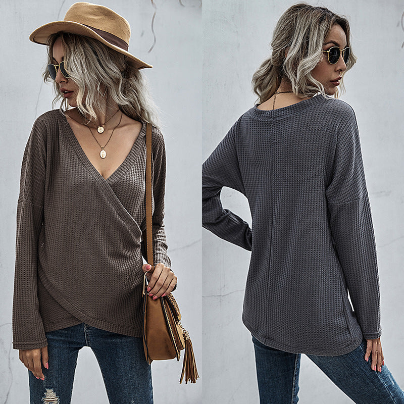 Woman in a waffle knit V-neck long sleeve top, ripped jeans, and tan hat, FashionRay style