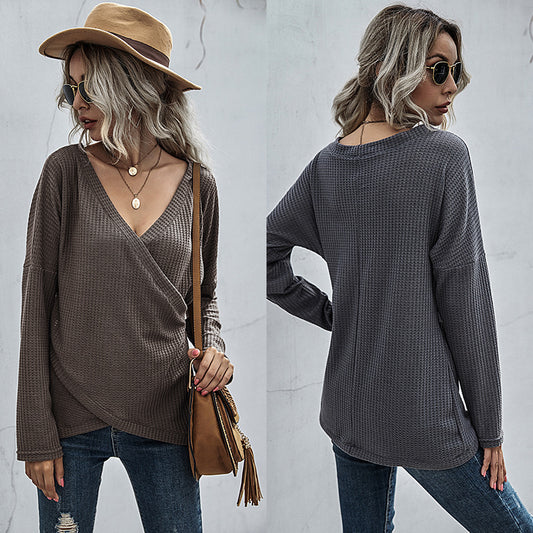Woman in a waffle knit V-neck long sleeve top, ripped jeans, and tan hat, FashionRay style
