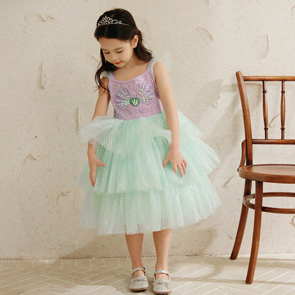 Girl in a pastel sequin princess dress and tiara stands by a wooden chair, FashionRay style