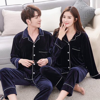 Couple wearing matching navy blue velvet pajamas sitting on a sofa, FashionRay comfy loungewear