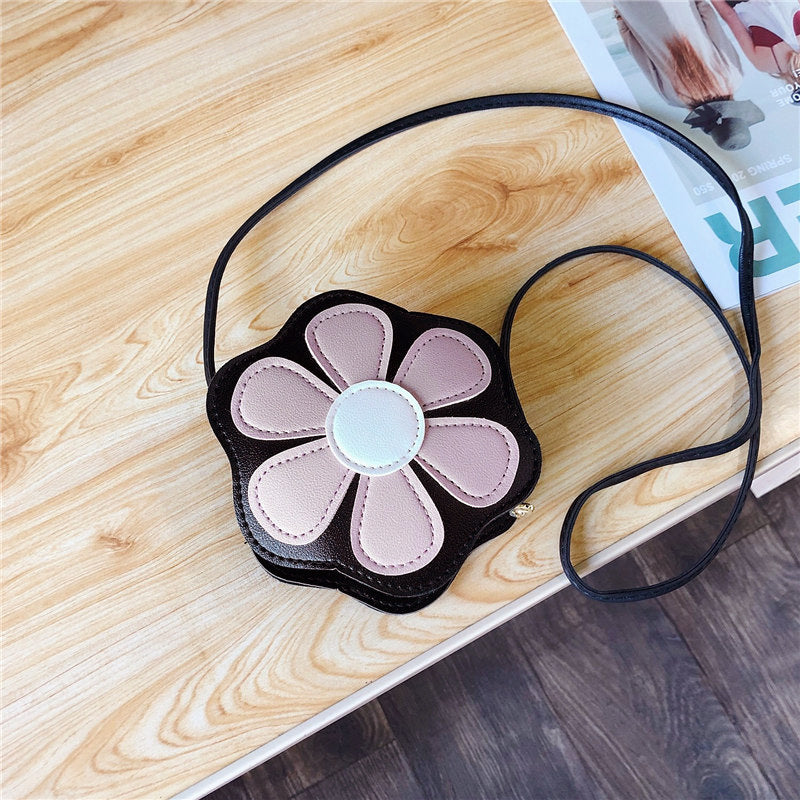FashionRay flower-shaped crossbody bag with pink petals on a wooden table