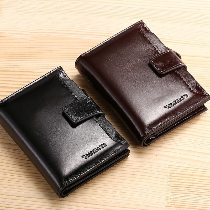 Black and brown leather wallets with clasp closures on a wooden surface, FashionRay accessories