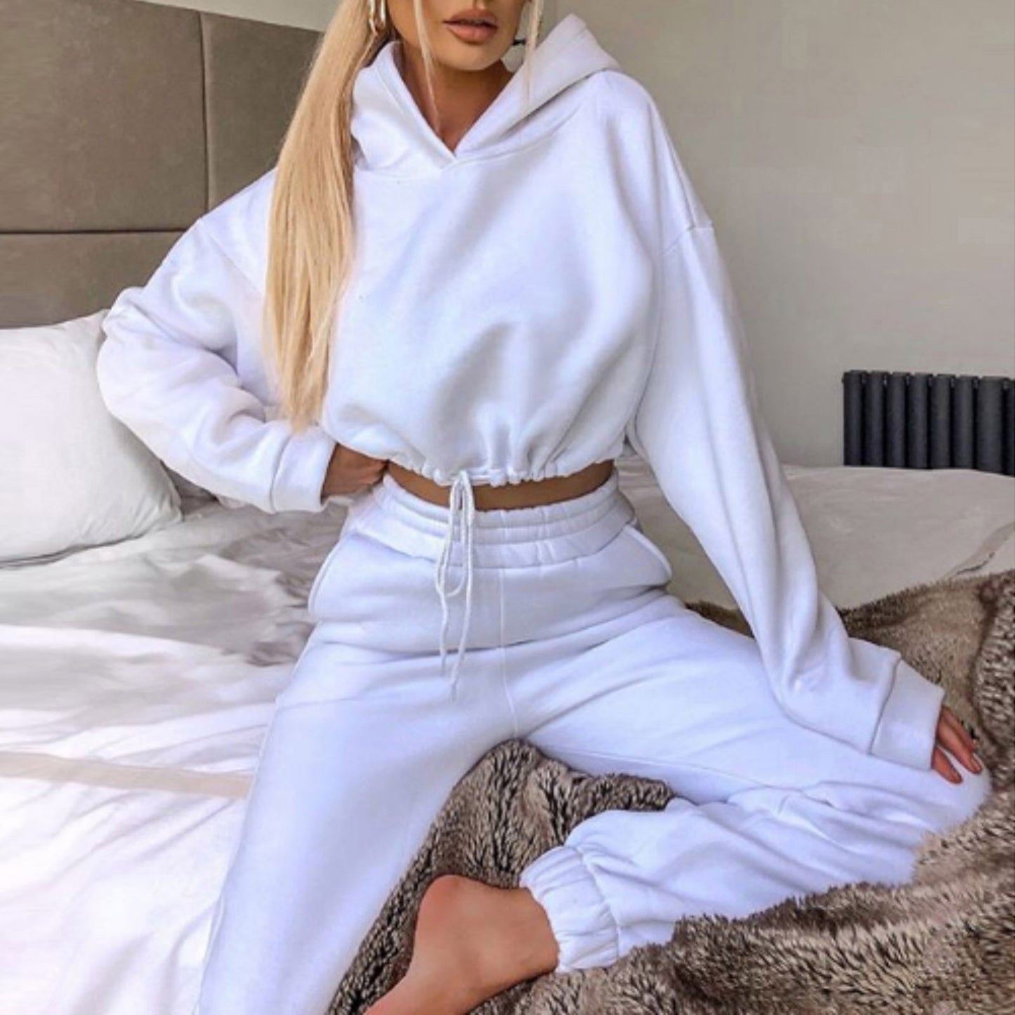 Woman in white hoodie and joggers loungewear set on bed, FashionRay casual style
