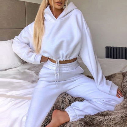 Woman in white hoodie and joggers loungewear set on bed, FashionRay casual style