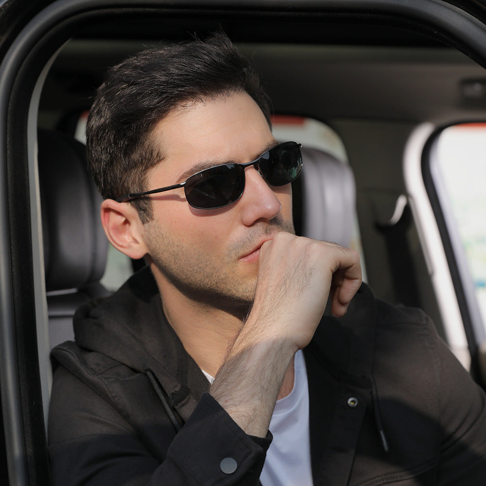 Man in black sunglasses and casual jacket seated in car, stylish comfort at FashionRay