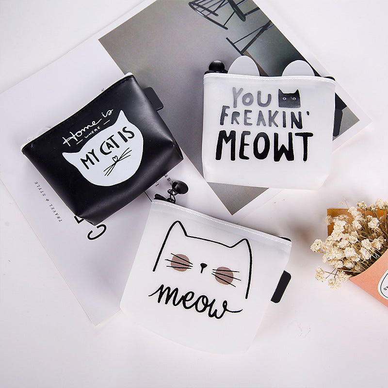 FashionRay cute cat-themed coin purses in black and white on a flatlay with flowers