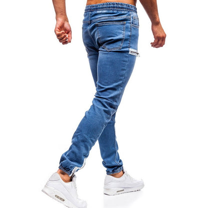 Man wearing blue jogger jeans and white sneakers, showcasing trendy FashionRay streetwear.