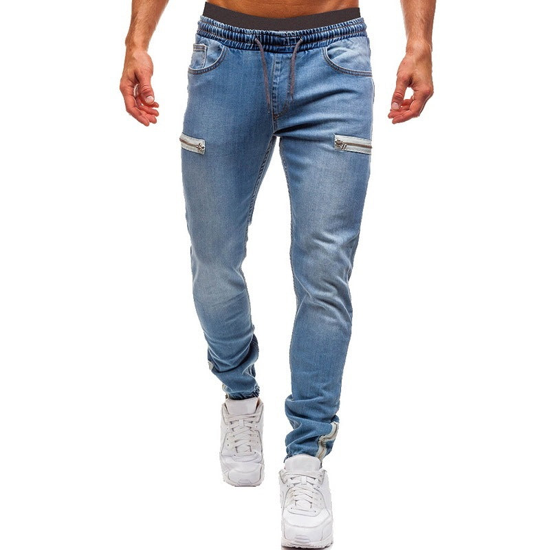 Men’s light blue denim joggers with zippered pockets, styled casually for FashionRay.