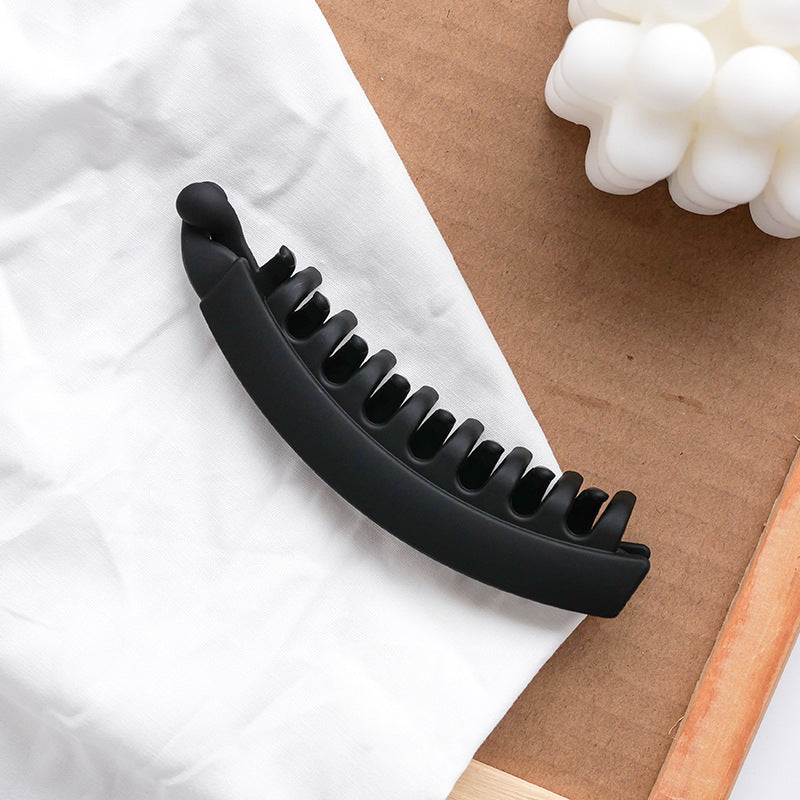 Matte black hair clip on white fabric, FashionRay trendy accessory