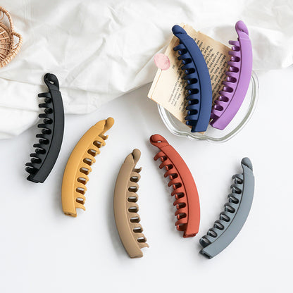 Assorted matte banana hair clips in neutral and bold colors on a white surface, FashionRay accessories