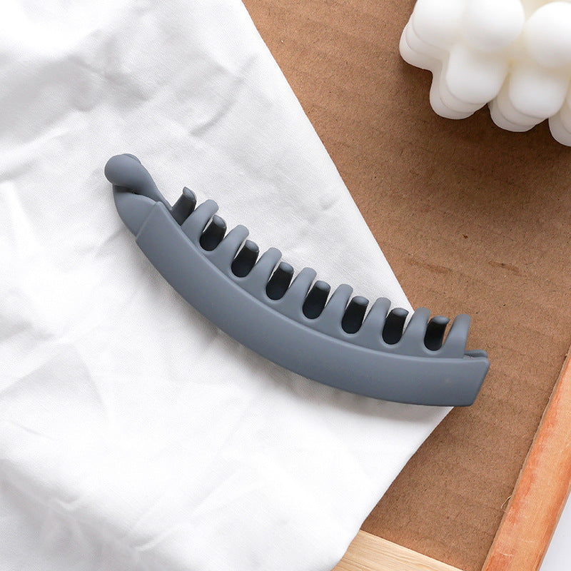 Gray hair claw clip on white fabric, minimal fashion accessory by FashionRay