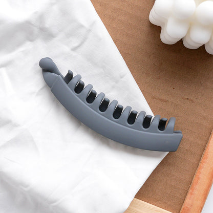 Gray hair claw clip on white fabric, minimal fashion accessory by FashionRay