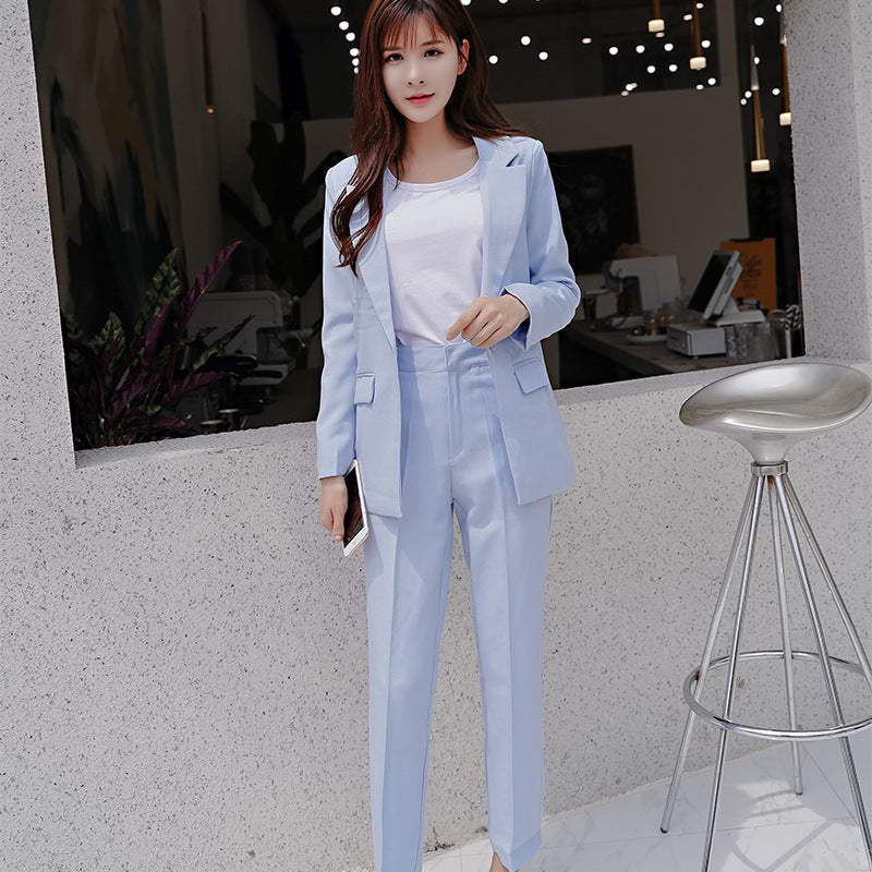 Woman in light blue suit with white top at modern café, trendy FashionRay style
