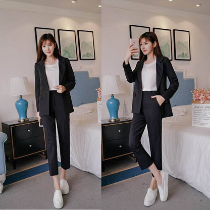 Woman wearing a black blazer suit with white t-shirt and slip-on shoes in a stylish bedroom