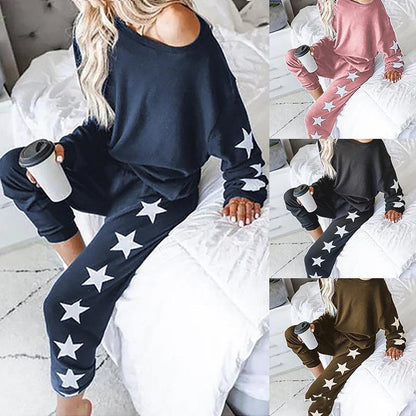 Woman in star print loungewear set available in multiple colors, sitting on bed with coffee.