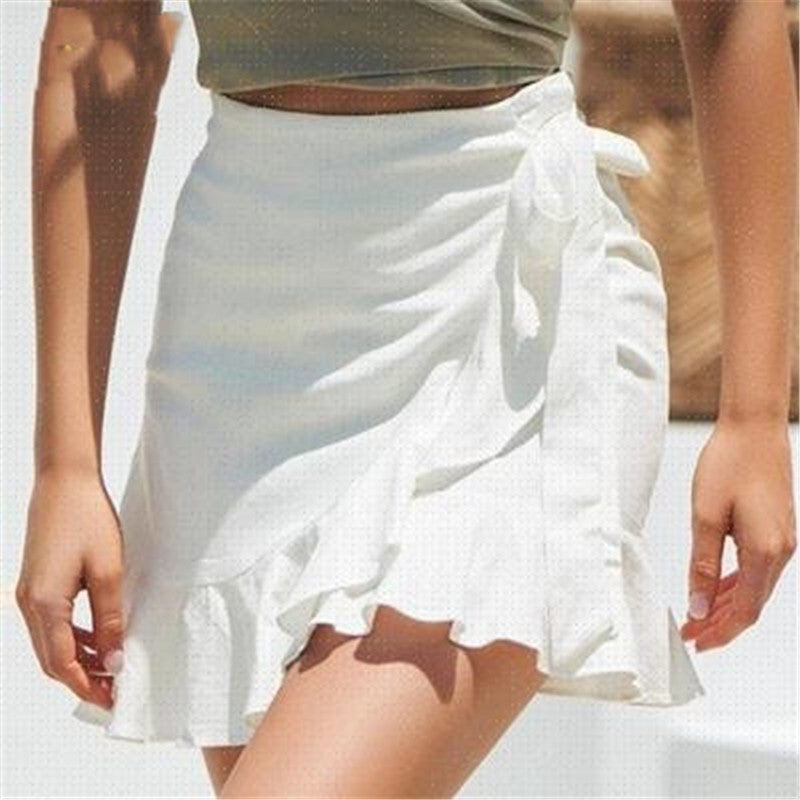 Woman wearing a white ruffle wrap skirt and green crop top, chic summer fashion style