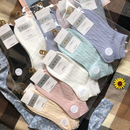 Assorted pastel and neutral women’s ankle socks with FashionRay tags on a plaid background
