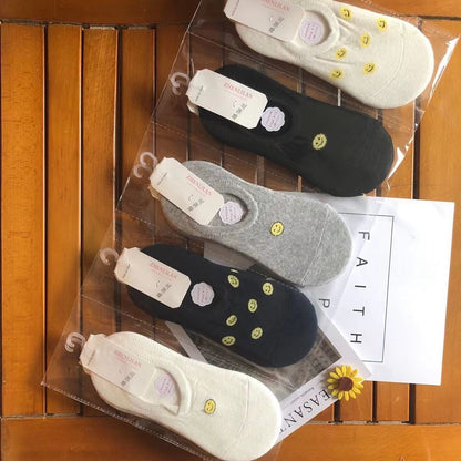 Pack of women's low-cut socks with smiley face design on wooden surface, FashionRay