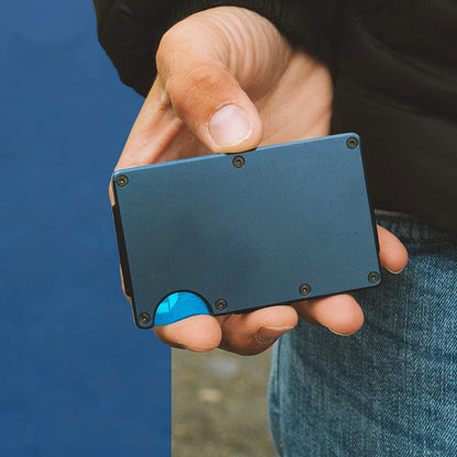 Hand holding a sleek blue minimalist metal wallet, showcasing modern fashion accessory