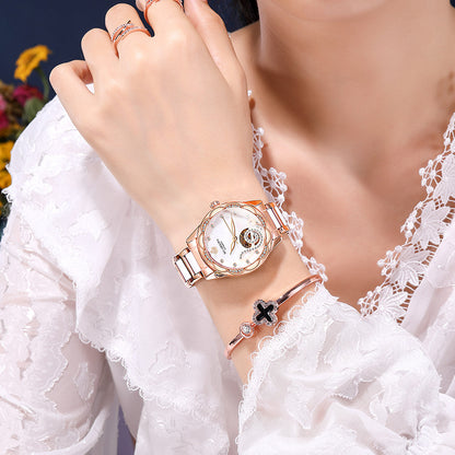Woman wearing rose gold watch and bracelet with lace white blouse, FashionRay style
