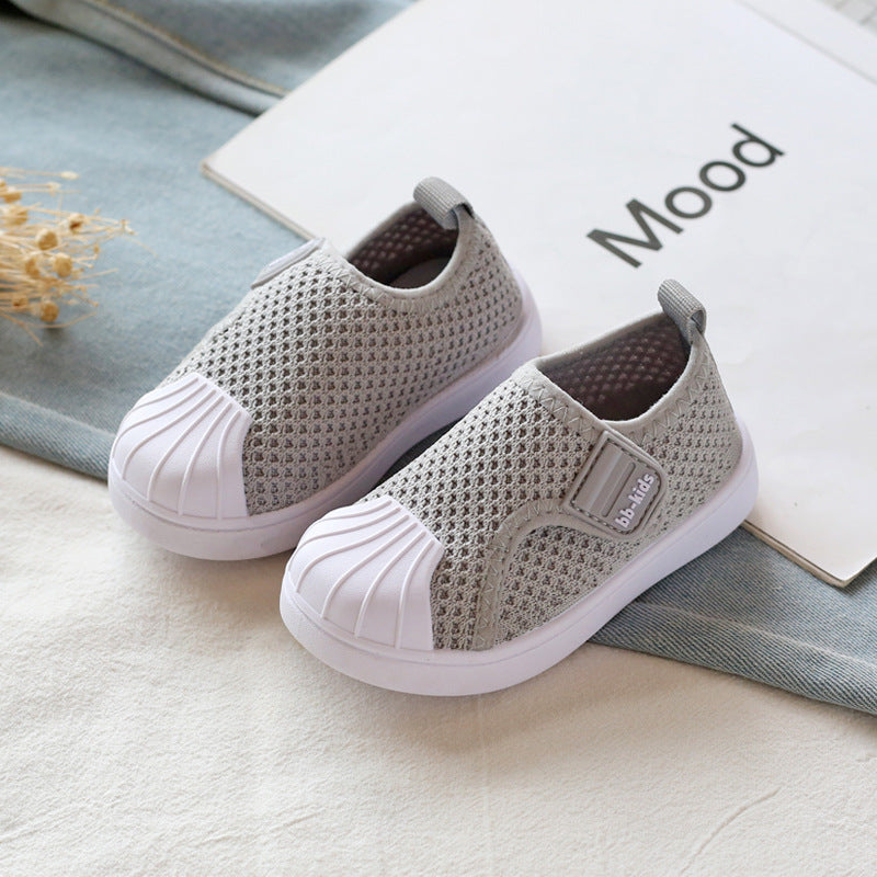 Gray mesh slip-on kids sneakers with white soles on a fabric surface, FashionRay style