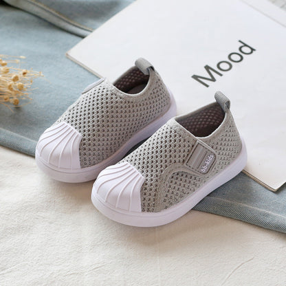 Gray mesh slip-on kids sneakers with white soles on a fabric surface, FashionRay style