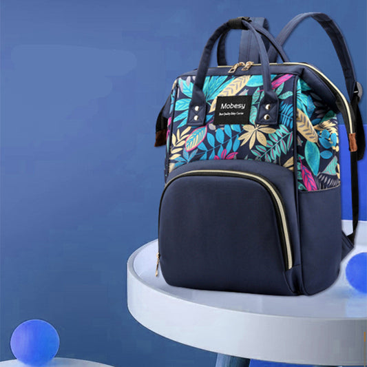 FashionRay navy blue backpack with colorful leaf print on table, trendy and stylish design