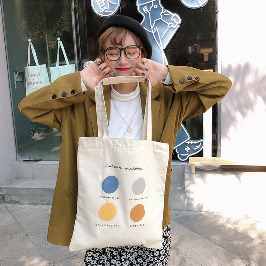 Trendy woman in olive blazer holding canvas tote bag with color palette design, FashionRay style