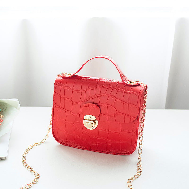 Bright red crocodile pattern handbag with gold chain, FashionRay trendy accessory on white table