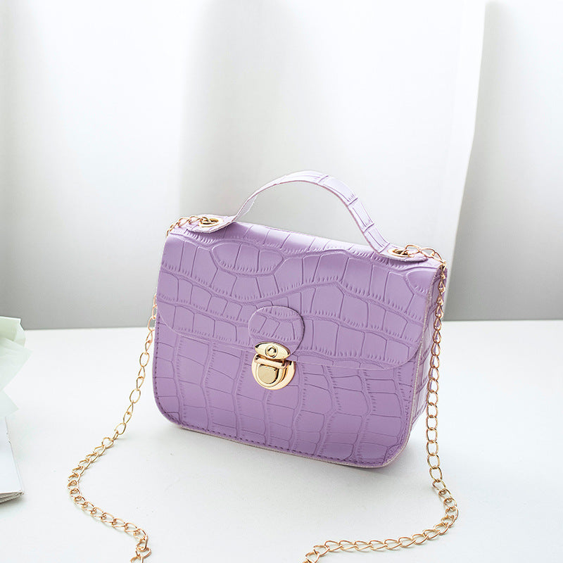 Purple crocodile-embossed handbag with gold chain strap on white background, FashionRay accessory