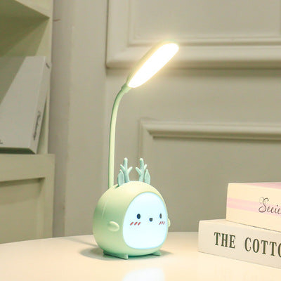 Cute mint green deer-shaped desk lamp glowing on a white table, stylish room decor