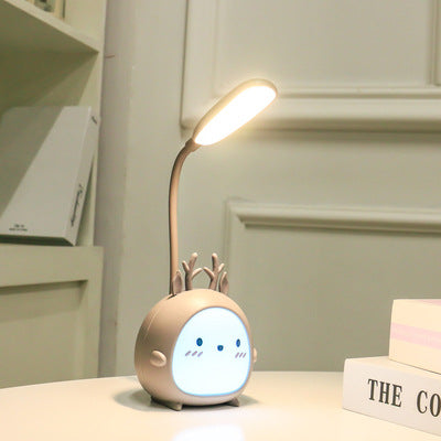 Cute LED desk lamp with a round, cartoon face and antler design on a modern table