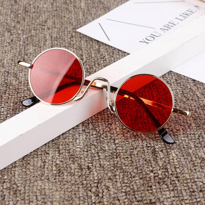 Trendy round sunglasses with red lenses and gold frames on a textured surface, FashionRay style