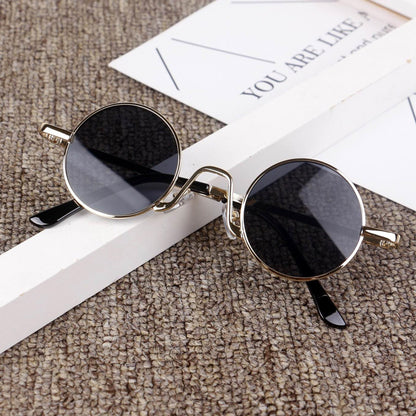 Round black sunglasses with gold frames on textured fabric, FashionRay trendy eyewear style