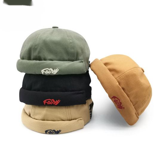 Stack of trendy cotton caps in green, black, beige, and tan with 'Fairy' embroidery, FashionRay