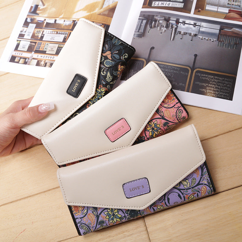 FashionRay stylish floral wallets with cream covers and colorful patterns on wooden table
