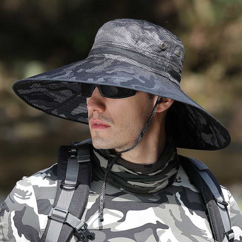 Man in camo shirt and wide-brim hat outdoors, wearing sunglasses and backpack, FashionRay style