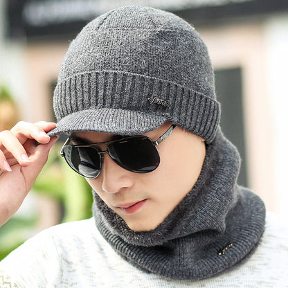 Man wearing gray knit hat, matching scarf, and sunglasses, stylish winter fashion at FashionRay