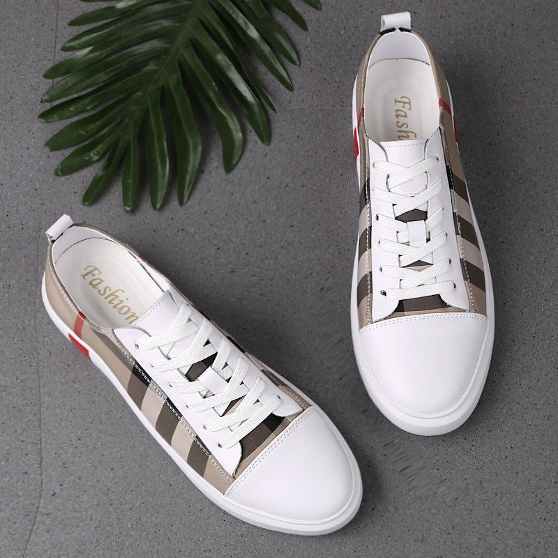 FashionRay stylish white sneakers with beige and black stripes on a gray surface with green leaf