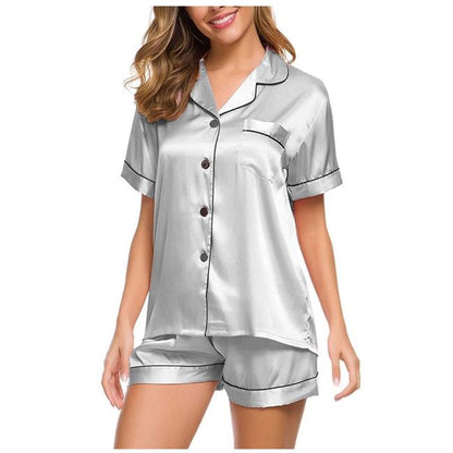 Woman wearing a silver satin pajama set with short sleeves and shorts from FashionRay.