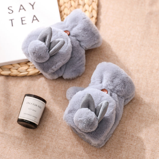 Plush gray bunny slippers with ears and tails on a beige surface, FashionRay cozy footwear.