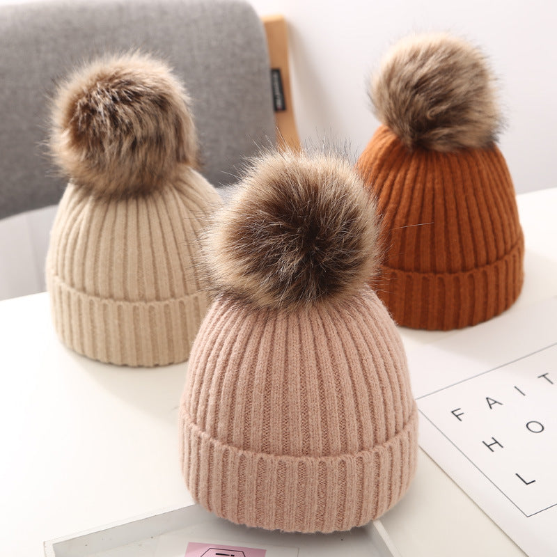 FashionRay ribbed knit pom pom beanies in beige, pink, and orange on a white table
